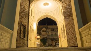 An arched entrance with a patterned facade and a central circular light fixture.