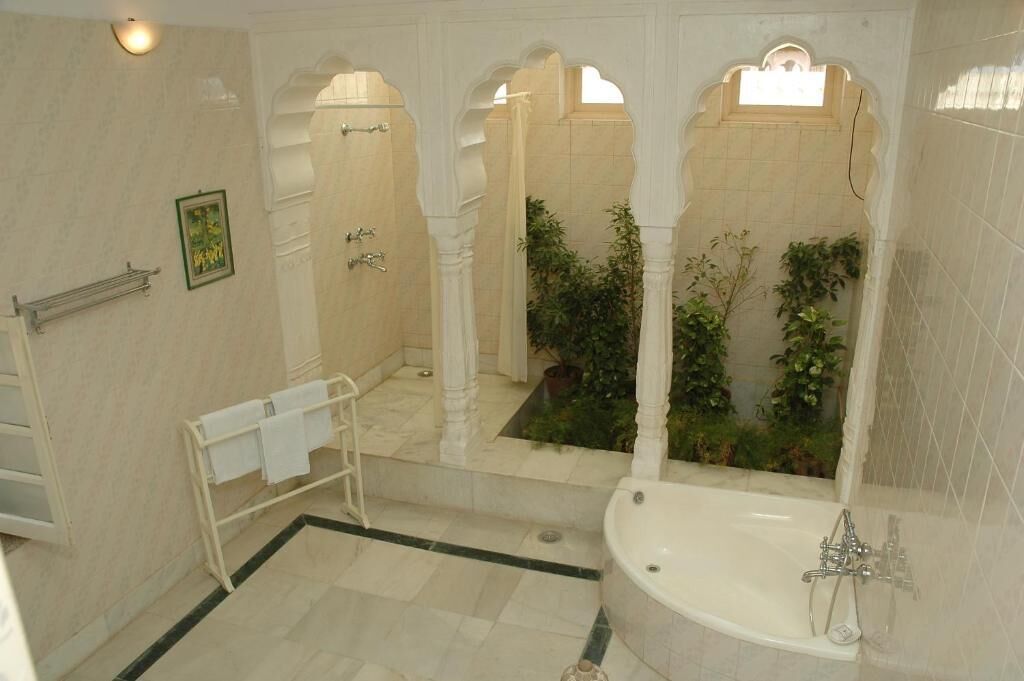 A bathroom with a bathtub, a towel rack, and a mirror.