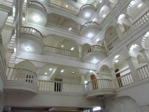 Un interno a più livelli con balconi e uno spazio aperto centrale.