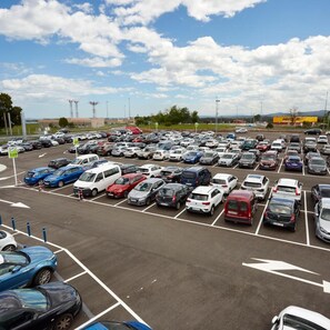 Un estacionamiento con varias filas de automóviles estacionados.