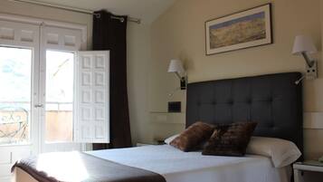 Habitación de hotel con cama, mesita de noche, lámpara y un cuadro en la pared.