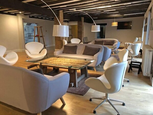A modern living room with contemporary furniture, a glass coffee table, and exposed ceiling beams. - Cueva Del Fraile (Buenache de la Sierra)