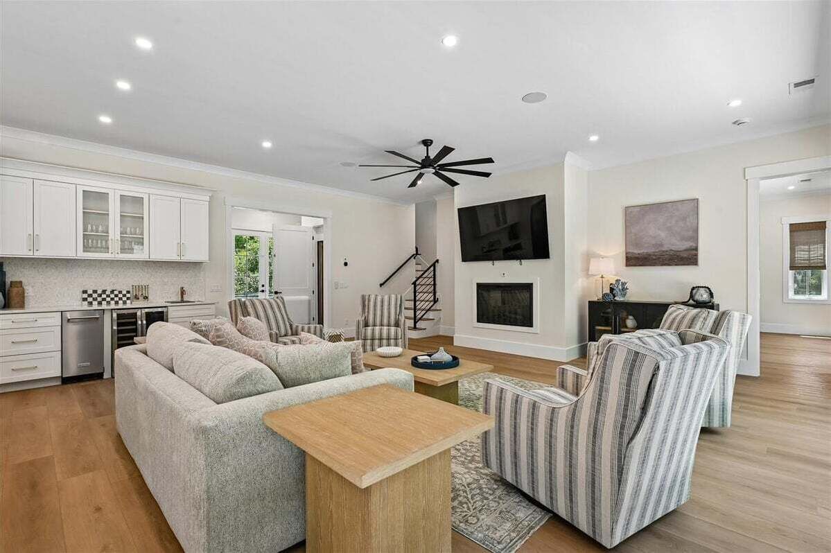 A modern living room with a sofa, armchairs, a coffee table, and a fireplace.