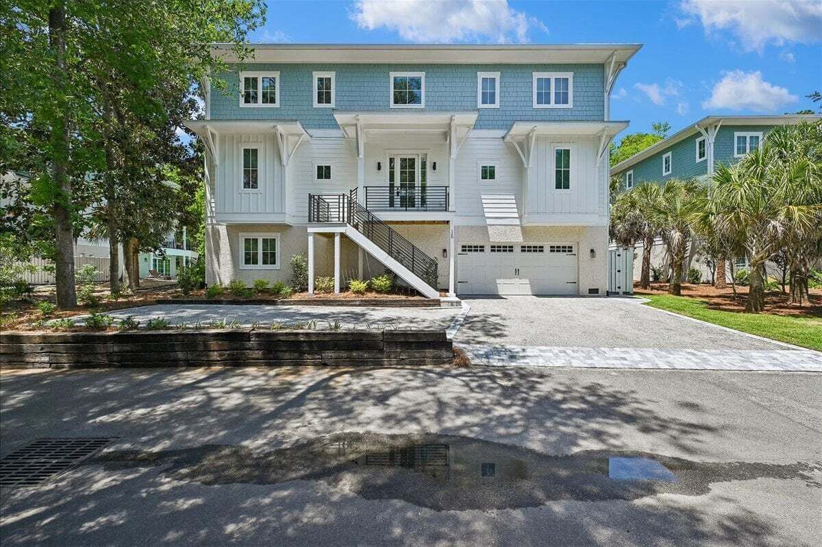 A multi-story residential building with a front entrance, a staircase, and a garage.