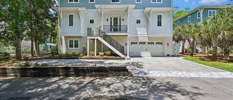 A multi-story residential building with a front entrance, a staircase, and a garage.
