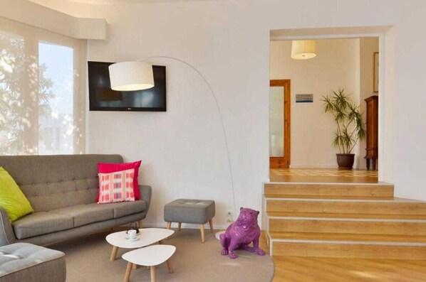 A modern living room with a sofa, coffee table, and a decorative dog statue. - Cenit Apartments (Ibiza Town)