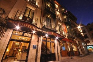 A hotel named "HOTEL RUA" with a classic European facade, large windows, and a visible entrance.