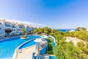 A resort with a large swimming pool, multiple balconies, and a view of the sea. - Apartamentos Vibra Caleta Playa (Ciutadella de Menorca)
