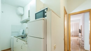 A compact kitchen with a refrigerator, microwave, and a small sink. - Hotel Las Palmas Urban Center (Las Palmas de Gran Canaria)