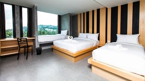 A modern hotel room with two beds, a desk, and a view of greenery. - B2 Phuket (Ratsada)