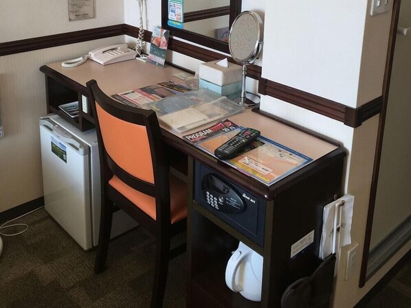 A compact hotel room with a small desk, a chair, a refrigerator, a microwave, and a small trash bin. - Toyoko Inn Tokyo Tachikawa-eki Kita-guchi (Tachikawa)