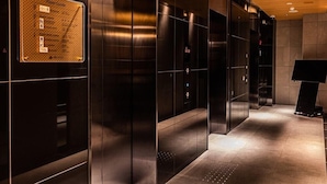 Een modern liftinterieur met metalen wanden en een etage-aanduiding.
