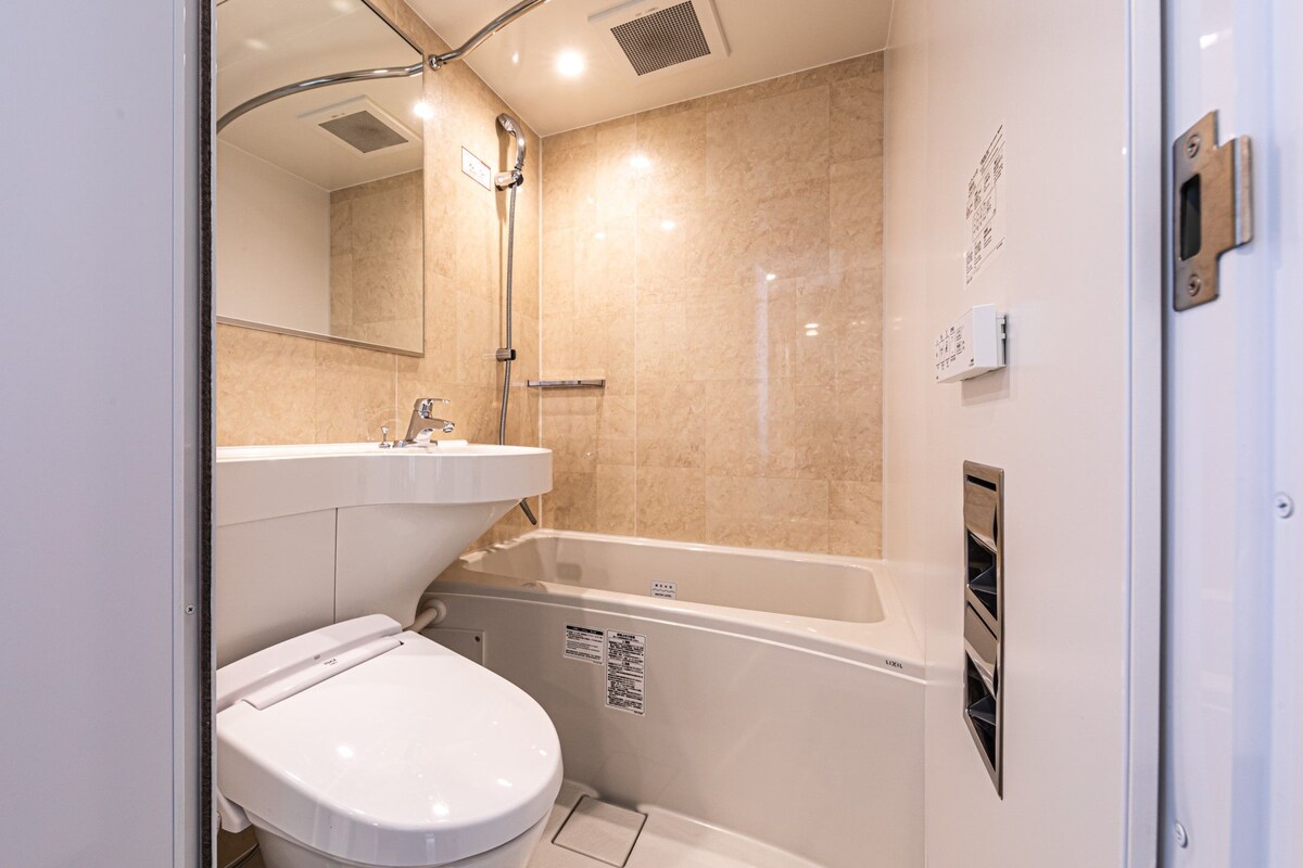 Een badkamer met toilet, wastafel en bad.