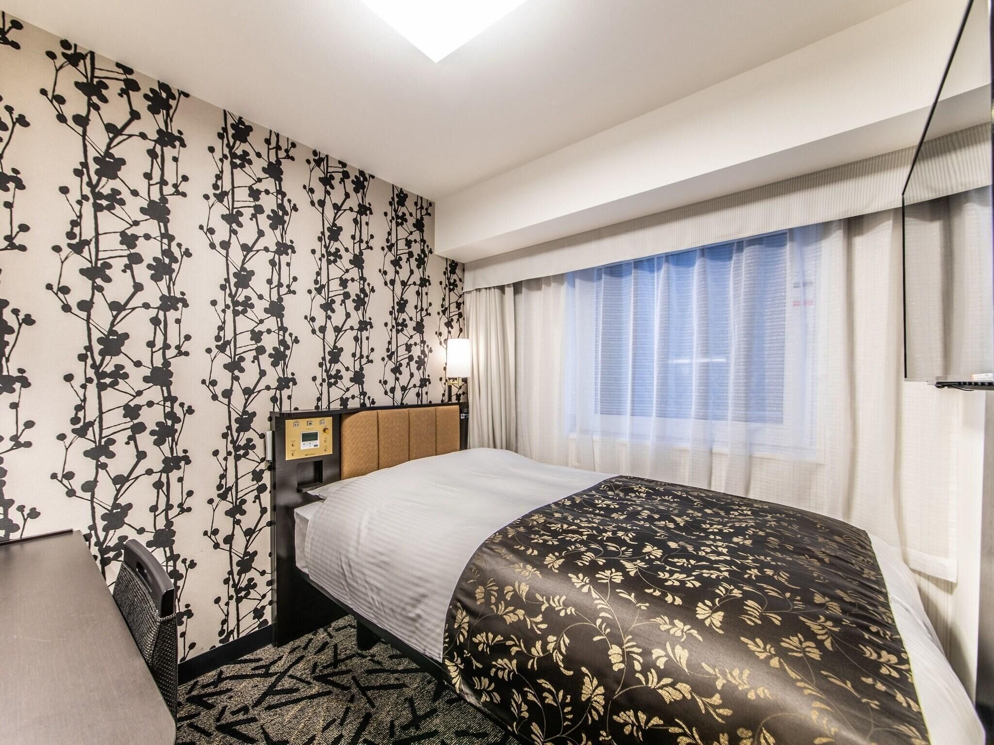 Ein Hotelzimmer mit Bett, Schreibtisch und Stuhl.