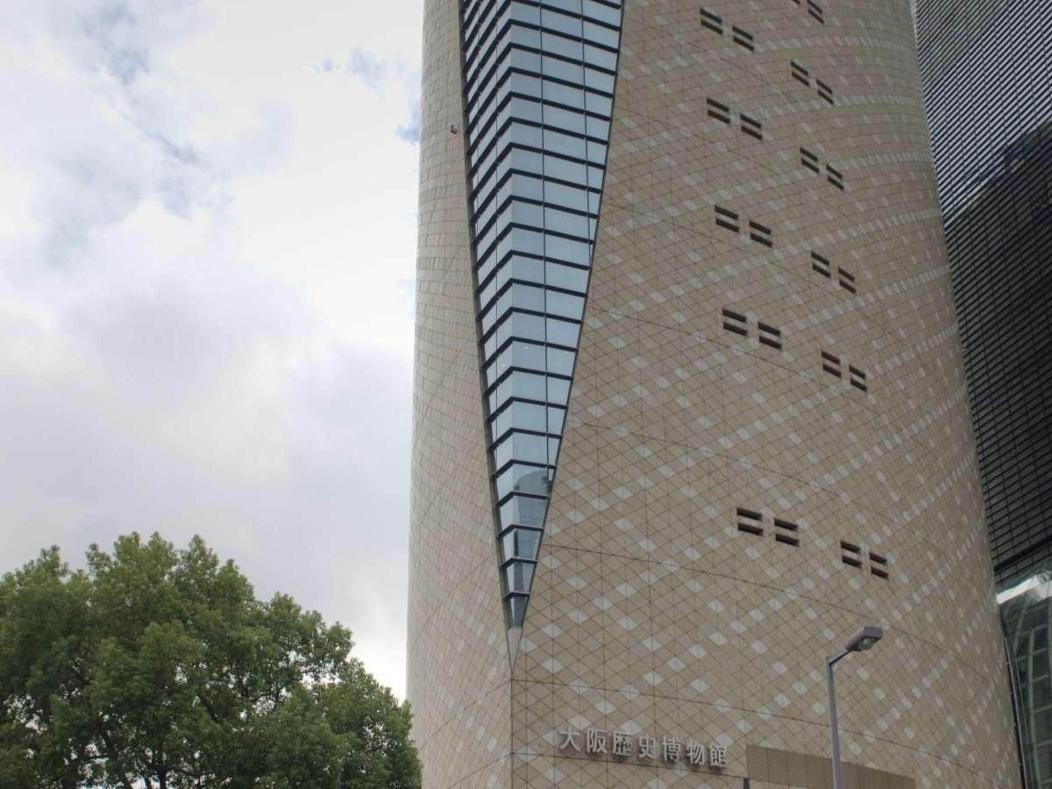Um edifício alto com fachada estampada e céu claro.