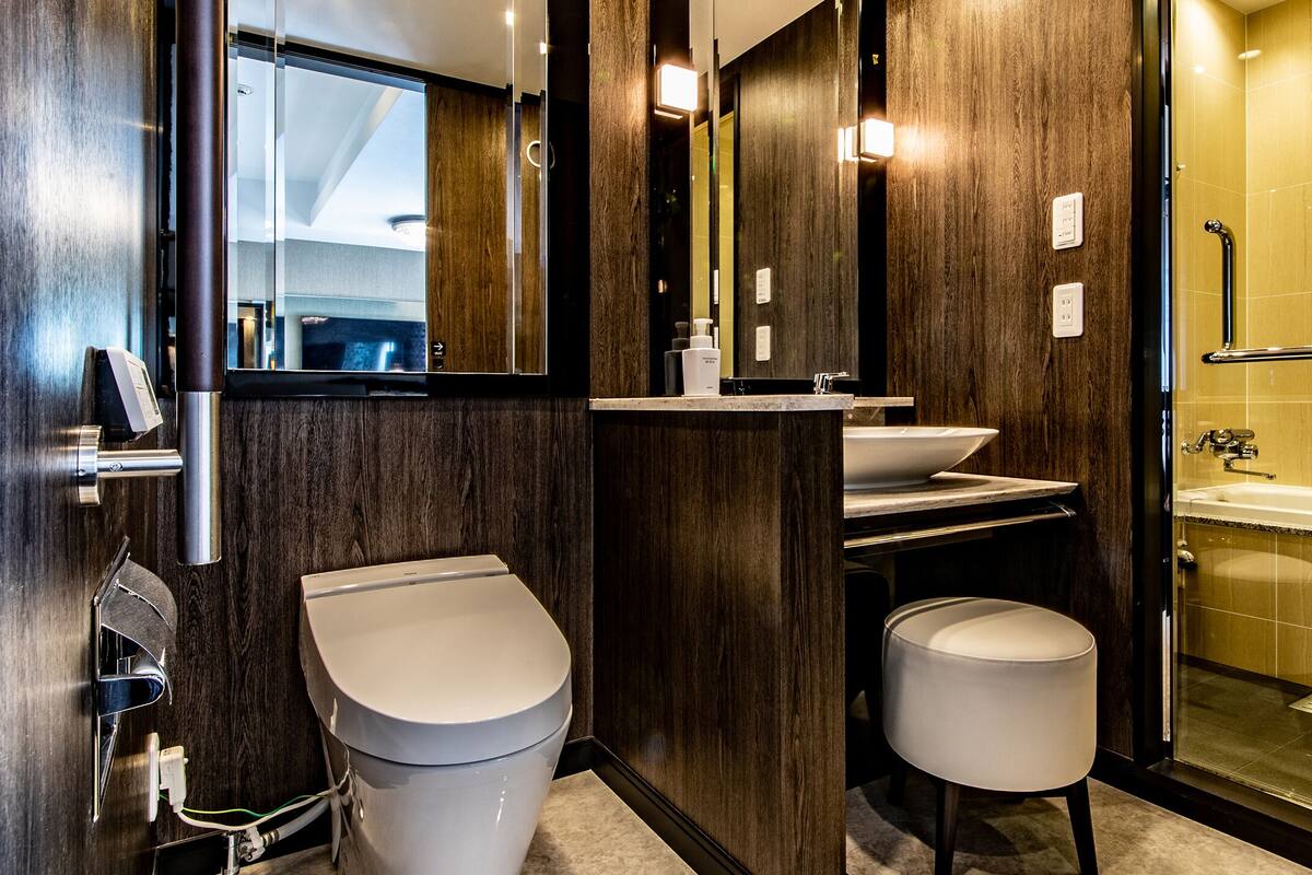 A modern bathroom with a toilet, sink, and shower.