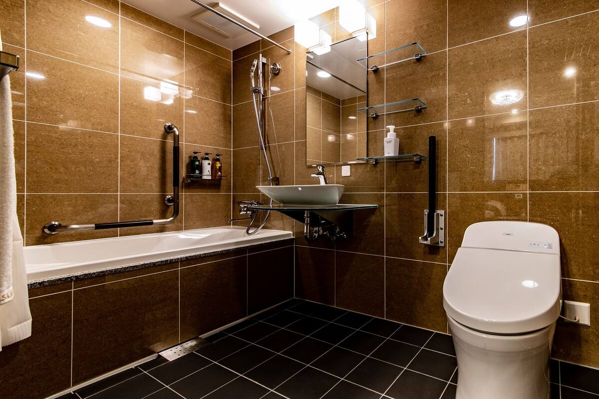 A modern bathroom with a bathtub, sink, and toilet.