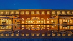 A large hotel with a reflective pool in front, multiple balconies, and a central entrance. - Sunshine Sazan Seto (Suooshima)