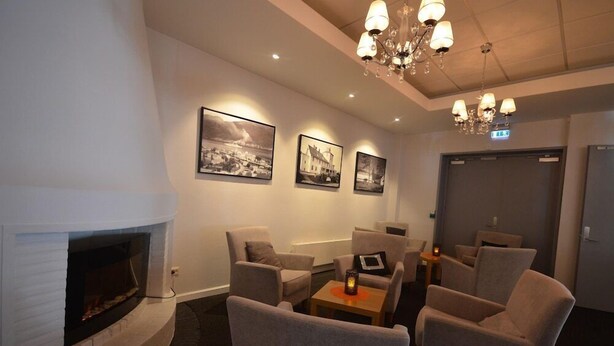 A room with a fireplace, comfortable seating, and wall-mounted artwork.