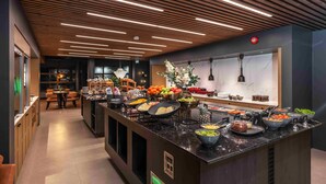 A modern kitchen with a central island, wooden ceiling, and various food items displayed. - Notodden Hotel (Notodden)