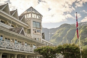 Un hotel con un estilo arquitectónico distintivo, que destaca por una torre imponente y varios balcones.