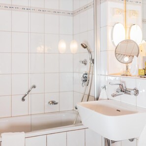 A bathroom with a bathtub, a sink, a shower, and a mirror. - Ullensvang (Ullensvang)