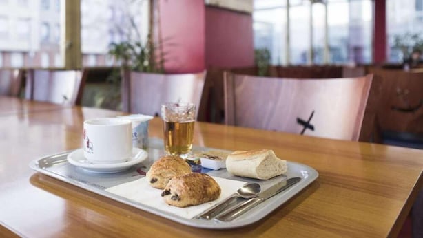 A tray with a cup, a glass of beer, and two pastries on a wooden table in a restaurant. - Les Gens de Mer (Dunkirk)