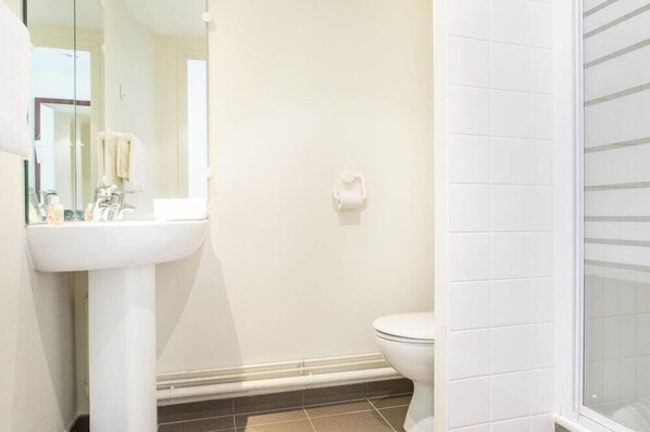A bathroom with a white sink, mirror, and toilet. - Les Gens de Mer (Dunkirk)