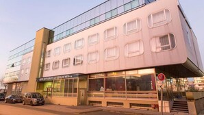 A hotel with a modern facade, multiple windows, and a sign indicating it is a restaurant. - Les Gens de Mer (Dunkirk)
