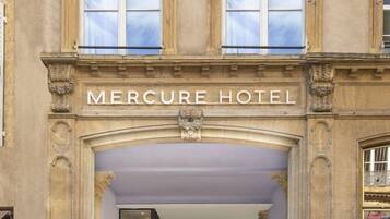 L’extérieur de l’hôtel Mercure se distingue par son imposante entrée, ses grandes fenêtres et ses éléments architecturaux classiques.