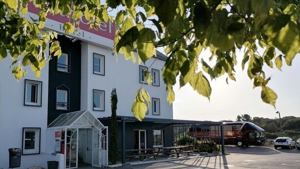 Un hotel con reception, area salotto esterna e patio coperto.