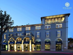 Ein mehrstöckiges Hotel mit Rundbogenportalen und Balkonen, das einen klassischen Baustil aufweist.