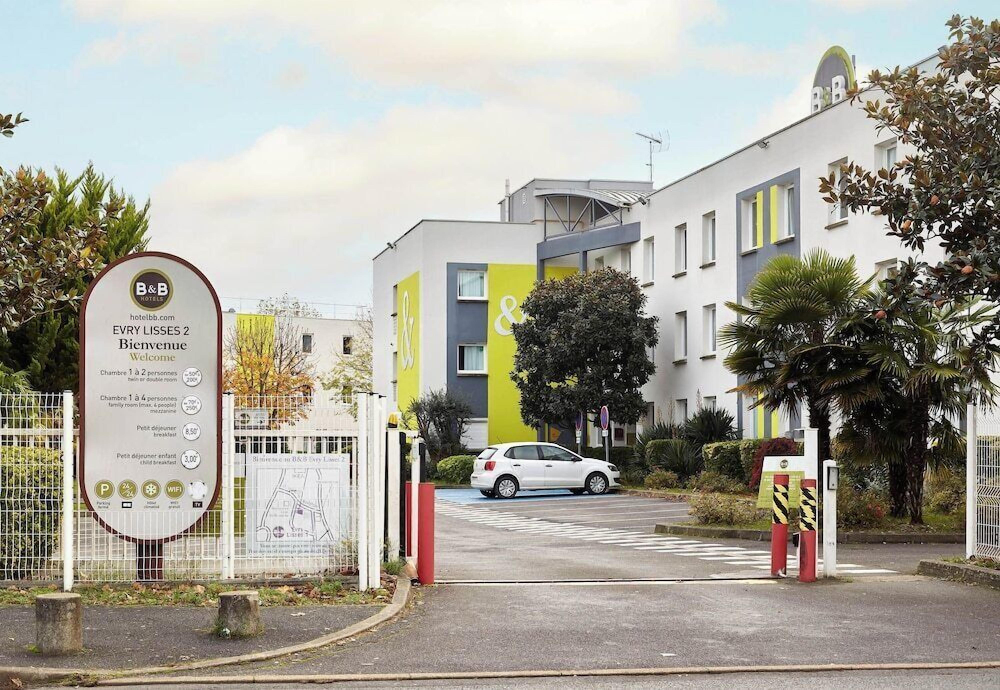 A hotel entrance with a sign indicating room availability and amenities.
