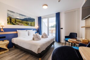 A hotel room with a bed, a desk, a chair, a window with curtains, and a painting on the wall. - Hotel Husseren Les Chateaux (Husseren-les-Chateaux)