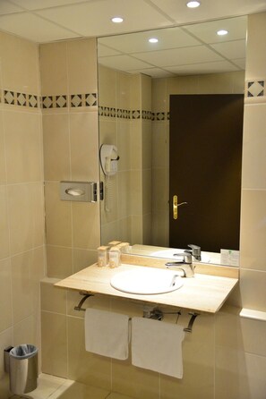 Baño con lavamanos, espejo, toallero y secador de pelo.