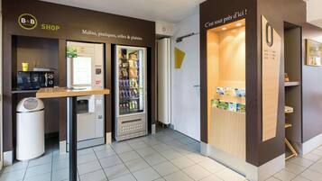 A B&B hotel shop with a vending machine, a coffee machine, and a self-service beverage dispenser.