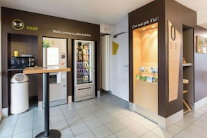 A B&B hotel shop with a vending machine, a coffee machine, and a self-service beverage dispenser. - B&B Hotel Rennes Nord St Gregoire (Saint-Gregoire)