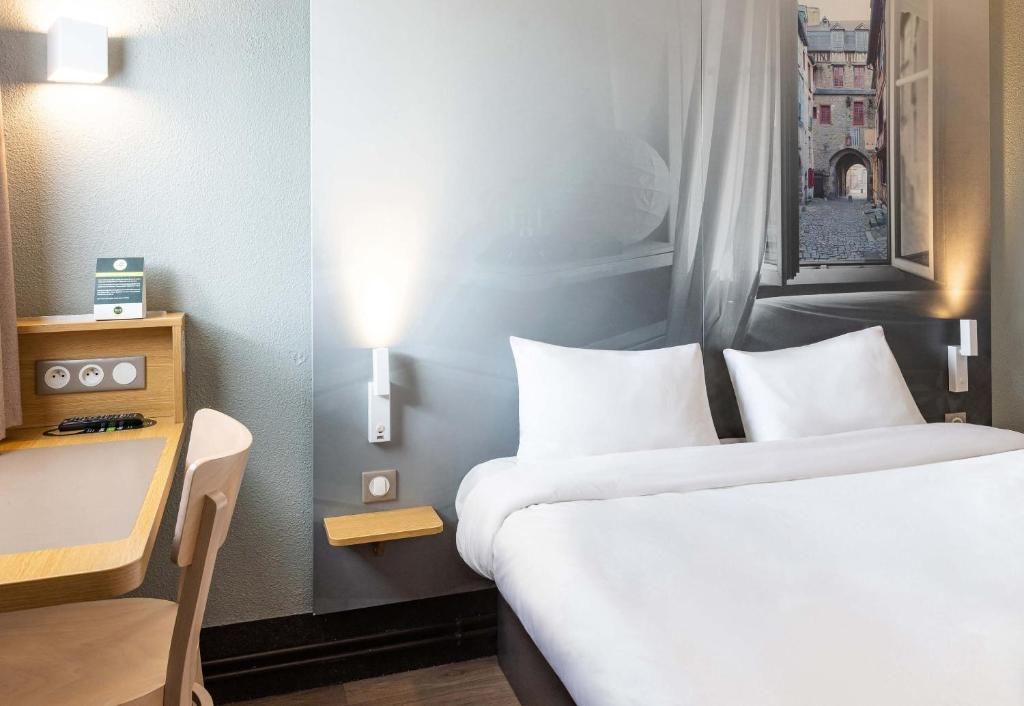 Hotellihuoneessa on sänky, työpöytä ja tuoli. Ikkunasta avautuu näkymä kadulle.