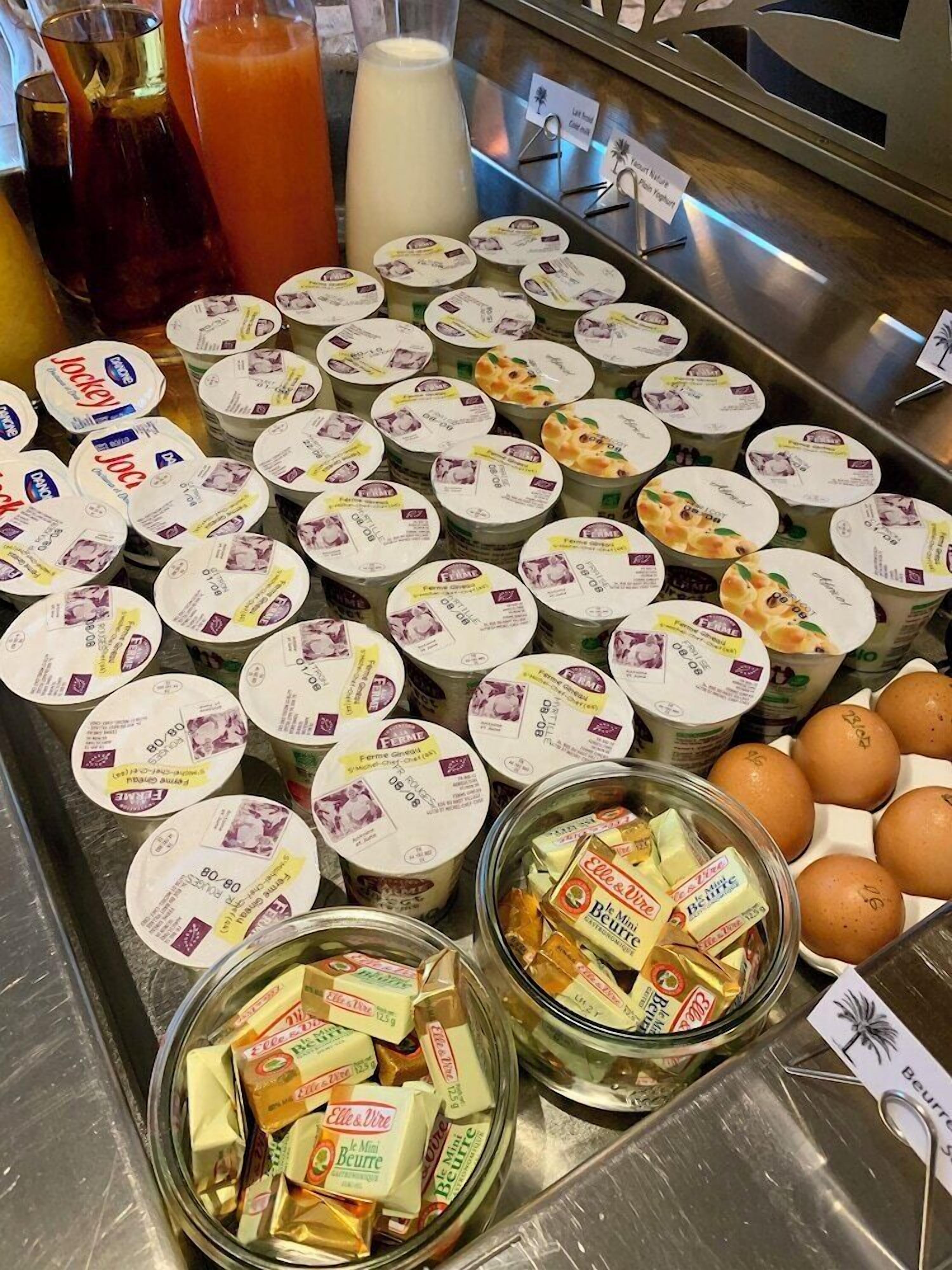 Un buffet proposant une variété d’aliments, notamment du yaourt, des œufs et du fromage.