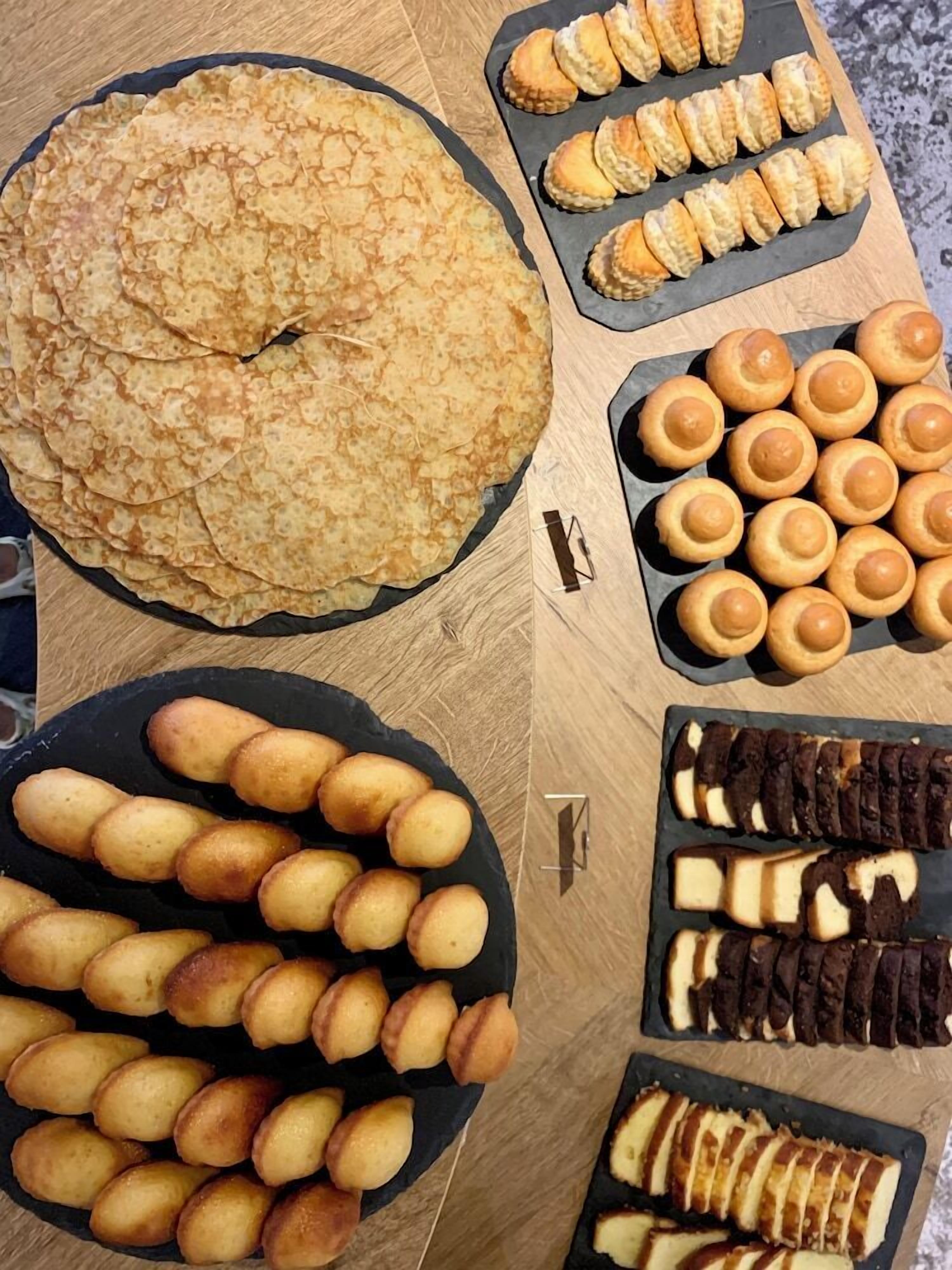Variedad de productos horneados, incluyendo un pastel grande y redondo, pequeñas pastas redondas y galletas rectangulares.