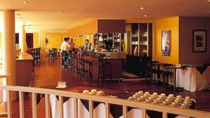 A restaurant with a bar area, multiple tables, and chairs. - Club Belambra Le Normont (Dourdan)