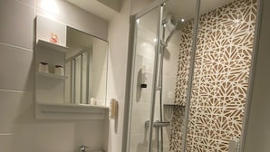 Une salle de bain moderne équipée de toilettes, d’un lavabo et d’une douche.