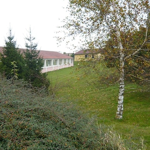 A residential area with a house featuring a red roof, a covered porch, and a well-maintained lawn. - Hotel Des Portes De Meuse (Pagny-sur-Meuse)