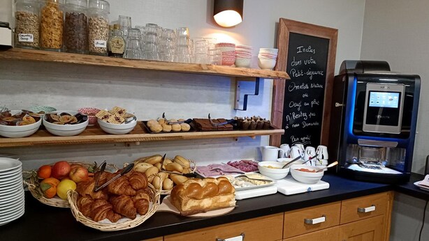 A breakfast buffet with various food items, a coffee machine, and a chalkboard menu. - Hotel Des Portes De Meuse (Pagny-sur-Meuse)
