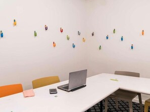 Una sala de conferencias con una computadora portátil sobre una mesa, sillas y una pizarra.