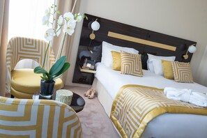 A hotel room with a bed, a chair, a small table, and a potted plant. - Quality Hotel Carlton Beaulieu (Beaulieu-sur-Mer)
