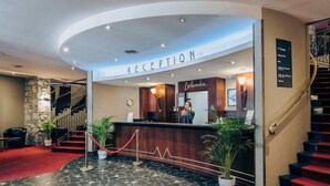 A reception area with a stone wall, a reception desk, and a staircase. - Hotel Tignes Le Diva (Tignes)