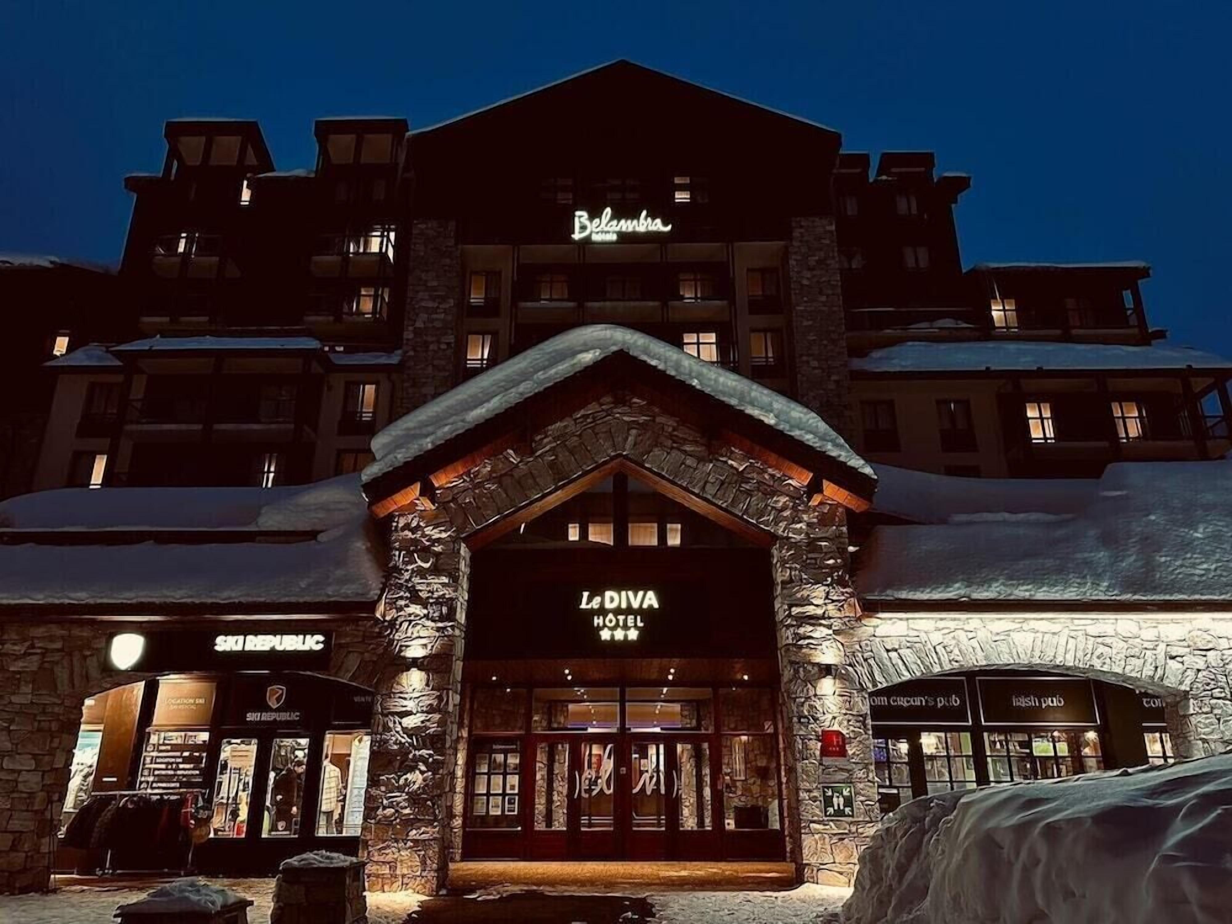 A hotel with a stone facade, a ski republic store, and a pub.