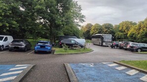 A parking lot with various vehicles, including cars and a camper van. - Village Hotel (Villefontaine)