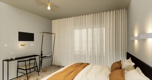 A hotel room with a bed, a desk, a chair, a standing fan, and a TV on the wall. - Citotel Leopol (Lorient)